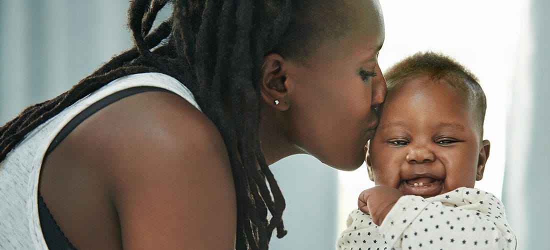African American mom kissing her baby