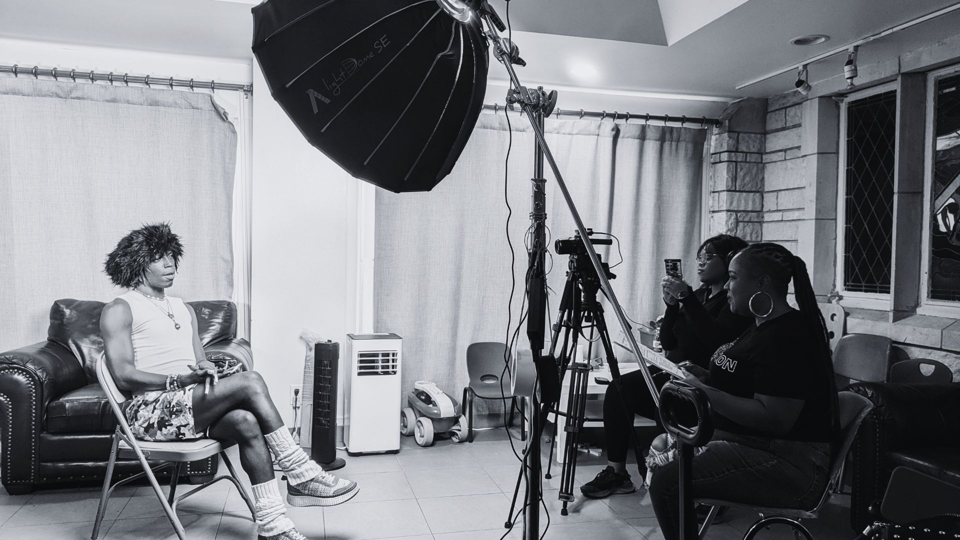 Behind the scenes filming ‘A Vision of Grace’, Josie Pickens interviews one of the youth as they sit in a folding chair. 