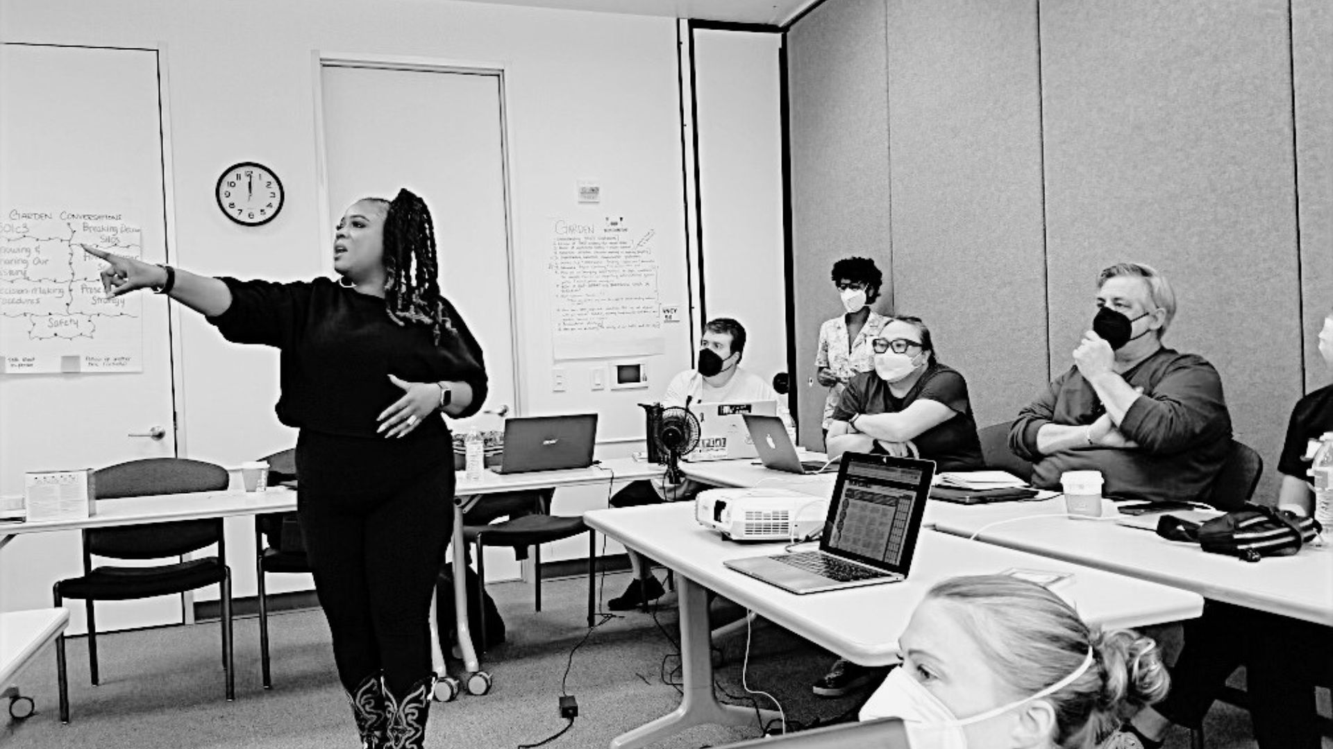 Josie Pickens gives a presentation to a group of organizers. She points at a presentation that is out of the frame.