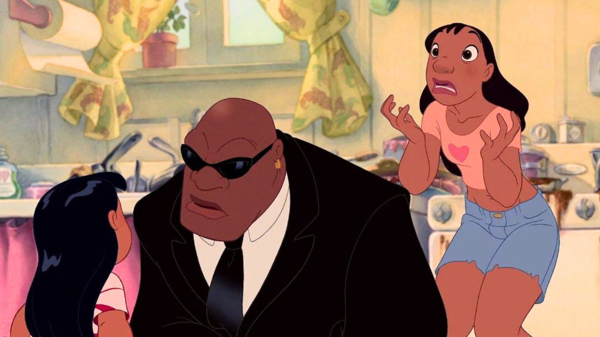 Social worker Bubbles investigates the family in Lilo & Stitch (2002). In this screenshot he is bending down to talk to Lilo while Nani stands behind him and looks scared.