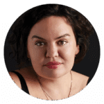 Roxanna Asgarian looks directly into the camera. She wears a gold chain and has curly hair that is pushed away from her face.